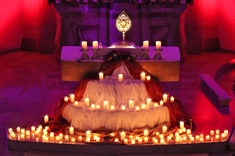 Bild des ausgestellten Allerheiligsten mit vielen Kerzen davor
